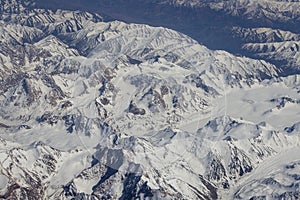 Aerial views in mountain. View from the plane window. The Hindu Kush mountain system in Afghanistan