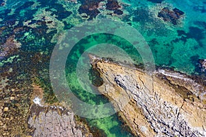 Aerial views of rocky coastal reef popular for swimming in Australia