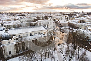 Aerial Vilnius city panorama in winter with snow covered houses, churches and streets. Cathedral square and Christmas tree. Winter