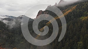 Aerial viw of fog among the mountain peaks. Bad weather and fog in the Siberian nature reserve Stolby.