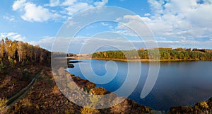 Aerial wide view of lake shore at sunrise in autumn. Meadows, orange grass, trees. Colorful landscape of river sunset. Horodok