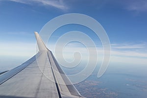 Aerial wing of airplane in bright blue sky day light using as va photo