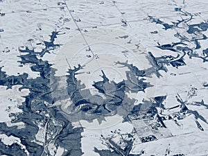 Aerial winter snow landscape view of rural and city land between Minneapolis Minnesota and Indianapolis Indiana with stark contras