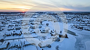 Aerial Winter Sunset Over Snowy Suburban Neighborhood