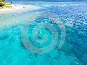 Aerial woman snorkeling on coral reef tropical caribbean sea, turquoise blue water. Indonesia Banyak Islands Sumatra, tourist