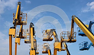 Aerial work platform of cherry pickers on blue cloudy sky background photo