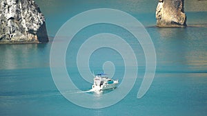 Aerial yacht on calm sea. Luxury cruise trip. View from above of white boat on deep blue water. Aerial top down view of