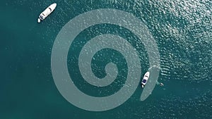 Aerial yacht on calm sea. Luxury cruise trip. View from above of white boat on deep blue water. Aerial view of rich