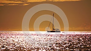 Aerial yacht on calm sea. Luxury cruise trip. View from above of white boat on deep blue water at sunset time