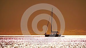 Aerial yacht on calm sea. Luxury cruise trip. View from above of white boat on deep blue water at sunset time