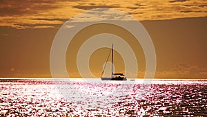 Aerial yacht on calm sea. Luxury cruise trip. View from above of white boat on deep blue water at sunset time