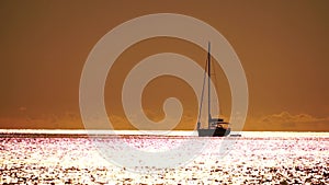 Aerial yacht on calm sea. Luxury cruise trip. View from above of white boat on deep blue water at sunset time