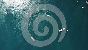 Aerial yacht on calm sea. Luxury cruise trip. View from above of white boats on deep blue water. Aerial view of rich