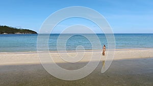 Aerial : Young Mixed Race Girl in Bikini Walking on the Beach. Koh Phangan, Thailand.