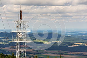 Aerials and transmitters on telecommunication tower with mountains in background