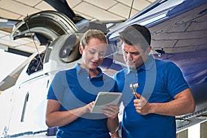 Aero Engineer And Apprentice Working On Helicopter In Hangar Loo photo