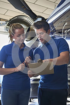 Aero Engineer And Apprentice Working On Helicopter In Hangar Loo