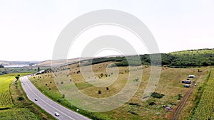 Aero shooting. panoramic view of green fields, valleys, coniferous forest, automobile highway. Transylvania, Romania