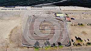 Aero, top view. Go-cart racing on circuit outdoors. There are safety barriers made of old wheels. Summer