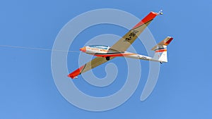 Aerobatic glider on blue sky, withe wings sport team