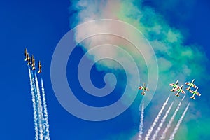 Aerobatic team in formation during aerobatic flight with smoke trails and multicolored sky