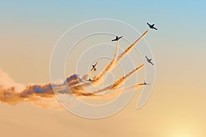 The aerobatic team of light fighters dissolves in the evening sky, leaving a smoky trail