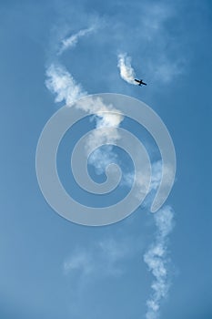 Aerobatics - aerobatic plane, airplane and aircraft is doing manoeuvres on clear blue sky