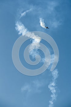 Aerobatics - aerobatic plane, airplane and aircraft is doing manoeuvres on clear blue sky photo