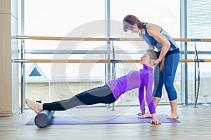 Aerobics Pilates personal trainer helping women group in a gym class