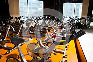 Aerobics spinning exercise bikes gym room in a row