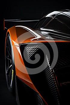 Aerodynamic orange exotic supercar detail of gloss carbon part with beautiful shapes.