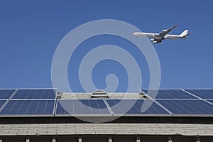 Aeroplane Flying Over Rooftop With Solar Panels