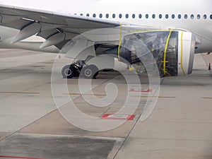 An aeroplane parking for repair on the airfield, plastic wrap with yellow tape at jet engine