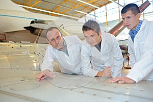 Aerospace engineers studying blueprint