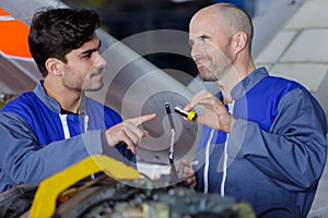 aerospace engineers using lamp to work on aircraft engine