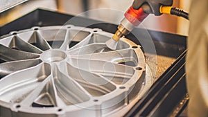 An aerospace part being postprocessed with a technician applying finishing touches using precision tools highlighting