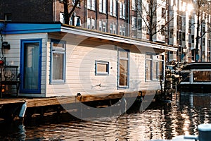 Aesthetic canals of Amsterdam at sunset, view from the water, houseboats on the canal, houseboats hotels. Romantic canal boat ride