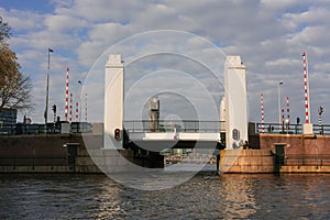 Aesthetic canals of Amsterdam at sunset, view from the water, view of the modern drawbridge from the river. Romantic canal boat