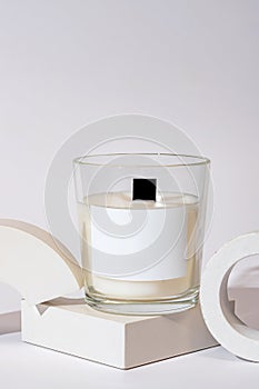 Aesthetic composition with aromatic candle in jar on concrete podium. Mockup soy wax candle in natural style. Scented