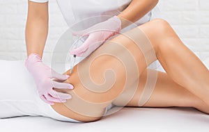 Aesthetic cosmetologist makes lipolytic injections to burn fat on the thighs and body of a woman. Female aesthetic cosmetology in