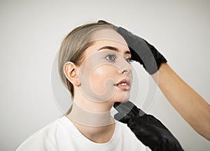 Aesthetic Cosmetology. Cosmetologist checking young woman face before beauty treatment