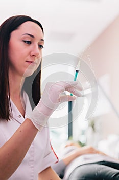 Aesthetic medicine doctor preparing syringe for injection