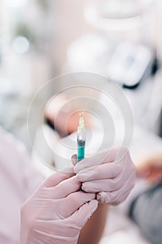 Aesthetic medicine doctor preparing syringe for injection