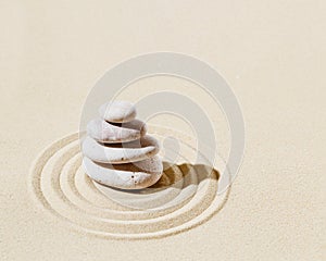 Aesthetic minimal background with zen stone on sand. Japanese Zen Garden with concentric circles around stone cairn.
