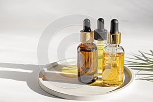 Aesthetic minimalist beauty care therapy concept. Organic serum oil cosmetics bottles on ceramic tray against white