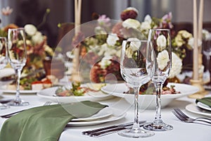 Aesthetic stylish autumn table setting background, arranged flowers and candles under natural light. Cozy holidays table