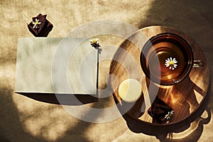 Aesthetic summer tea time, herbal tea and macarons dessert outside in the terrace under trendy hard shadows. Mock up of