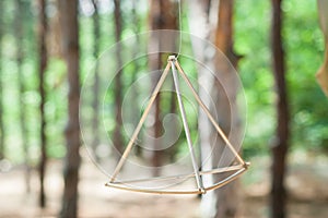 Aesthetic Tetrahedral Metal Decor Element Amidst a Forest Setting