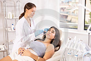 Aesthetician administering facial procedure on woman using ion bubble attachment