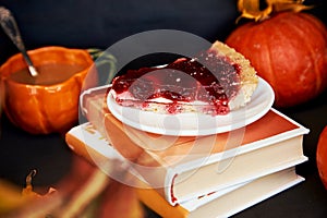 Aesthetics cozy home - autumn cup of coffee in shape of pumpkin, cherry pie and books. Atmospheric cozy coffee time